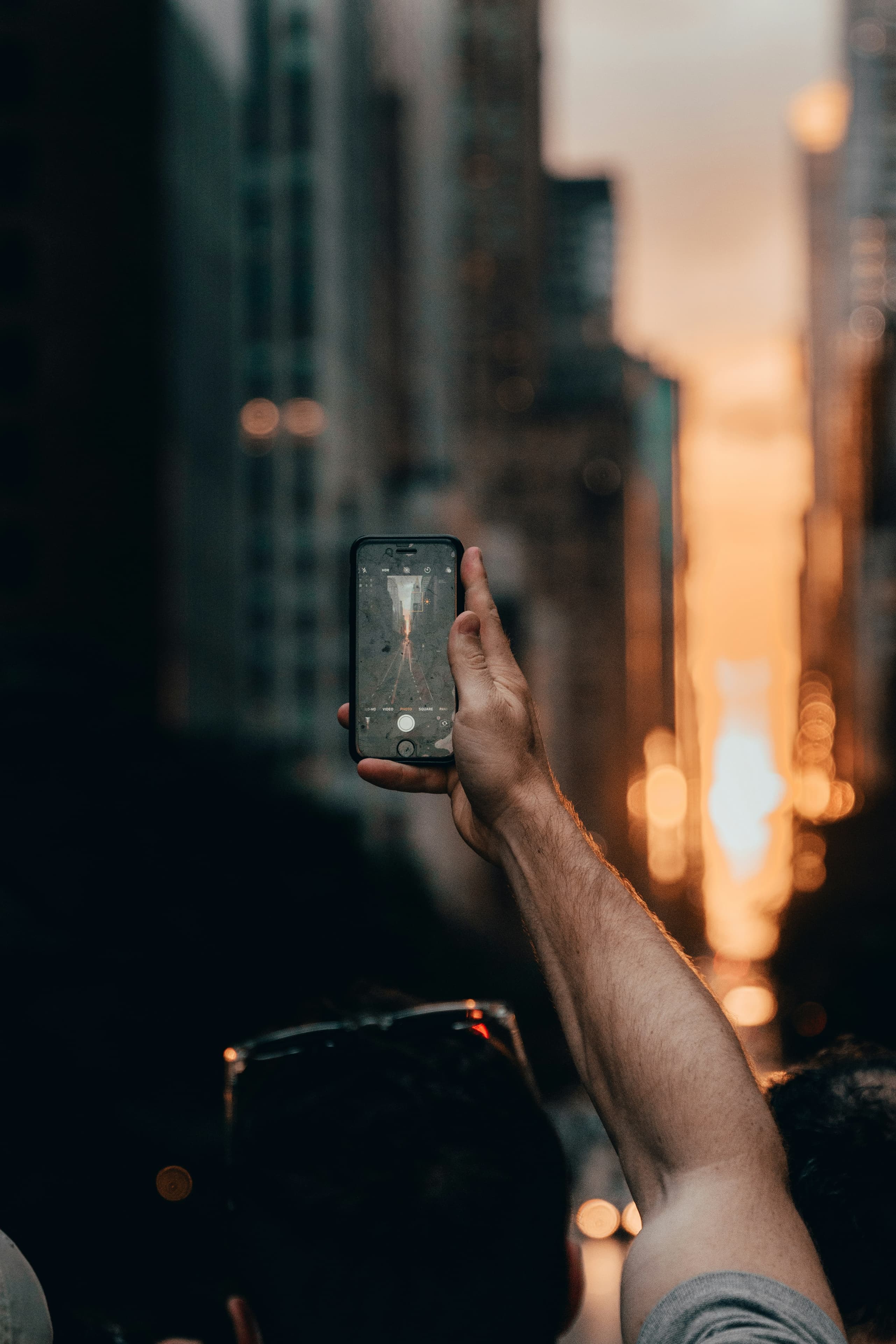 Gece şehirde elinde telefon tutan biri